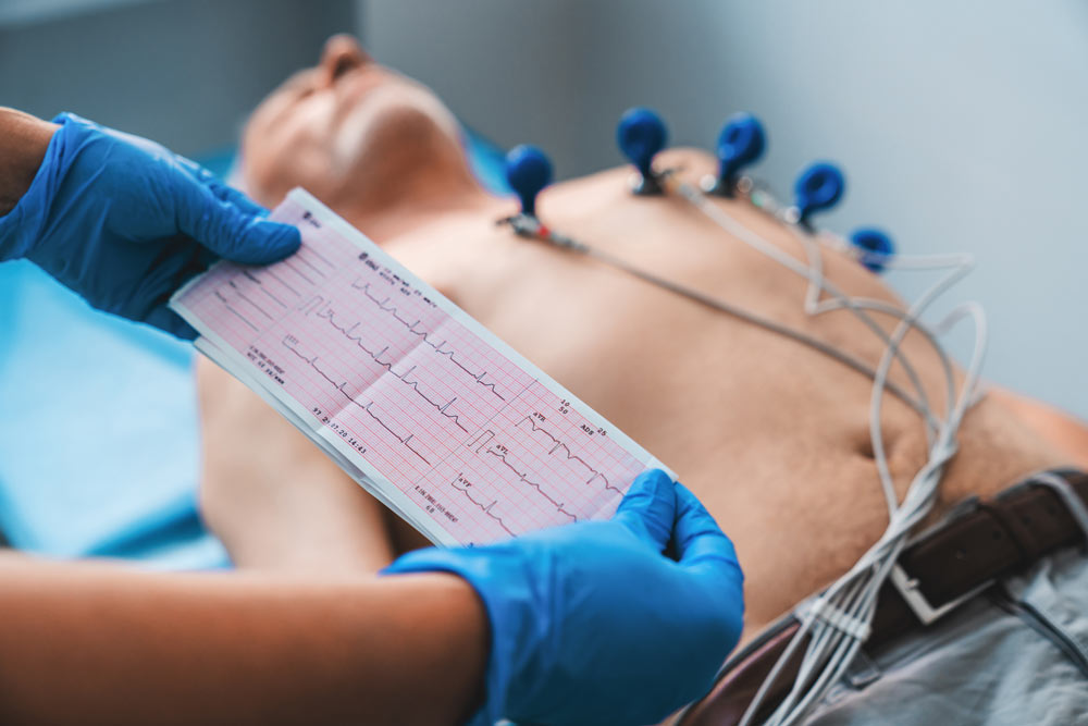 Technician performing a 12-lead EKG on a patient